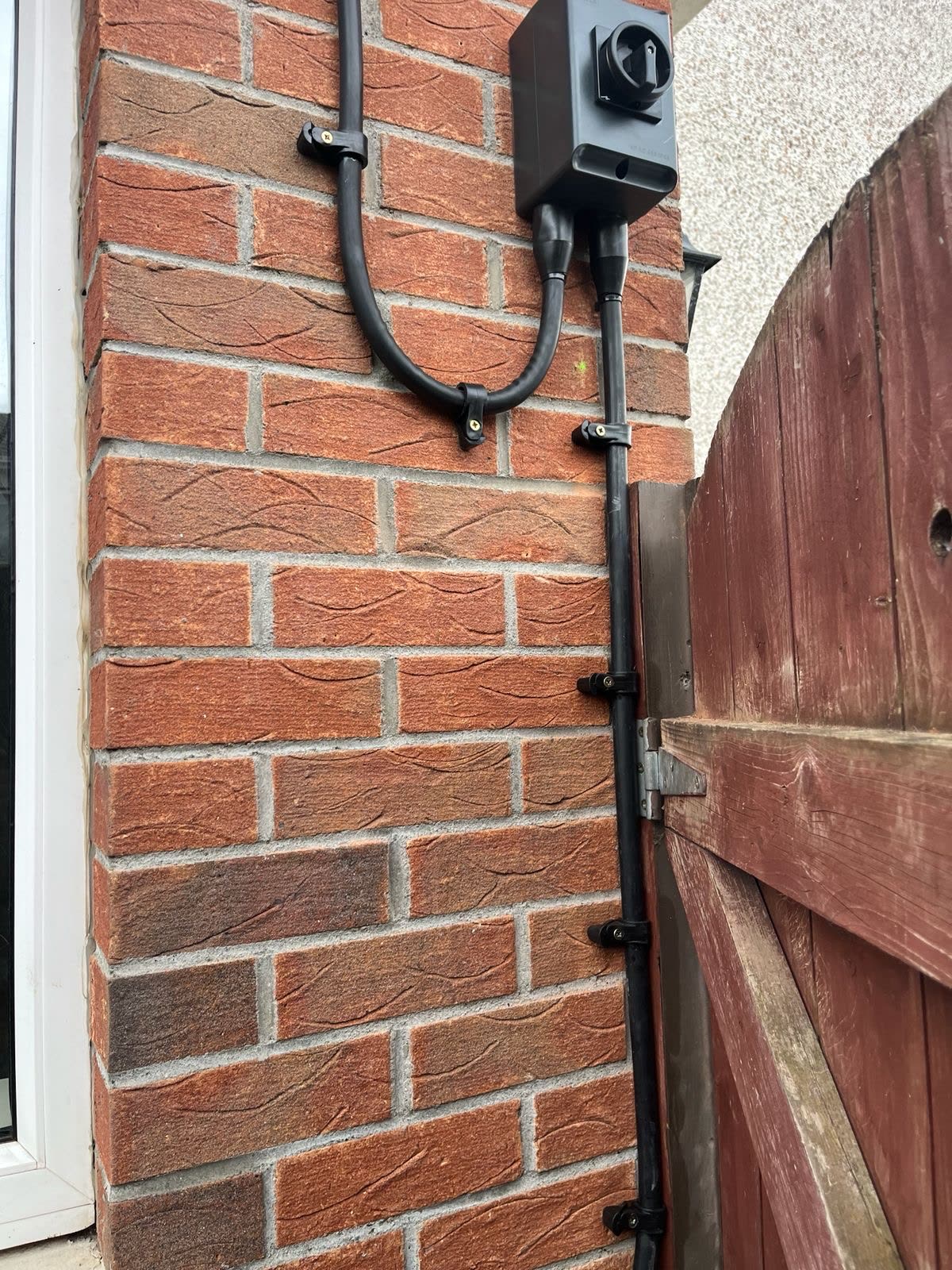 EV isolator and conduit run on brick wall